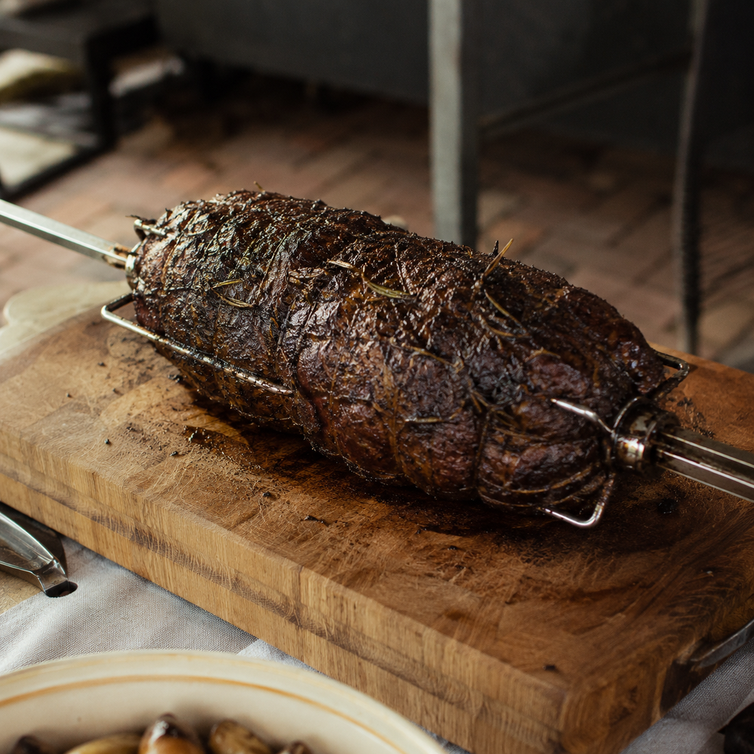 Charcoal rotisserie lamb roast cooked medium-rare with BBQ LAB Black Gold